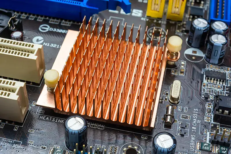 Close up view of copper heat sink or radiator on computer motherboard.