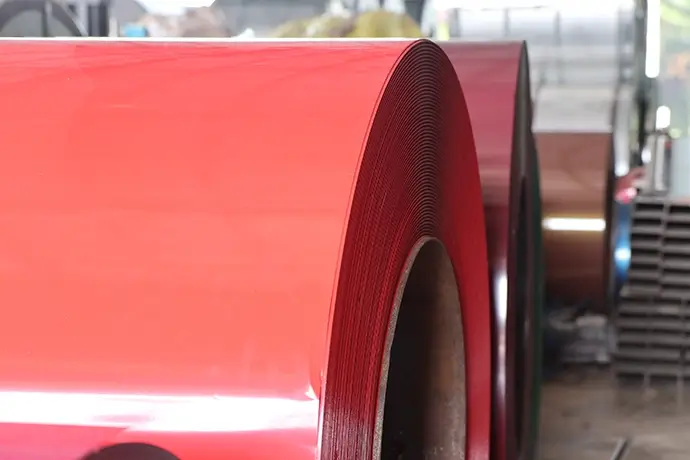 A section of sheet metal is pulled through a roll forming machine on a factory floor