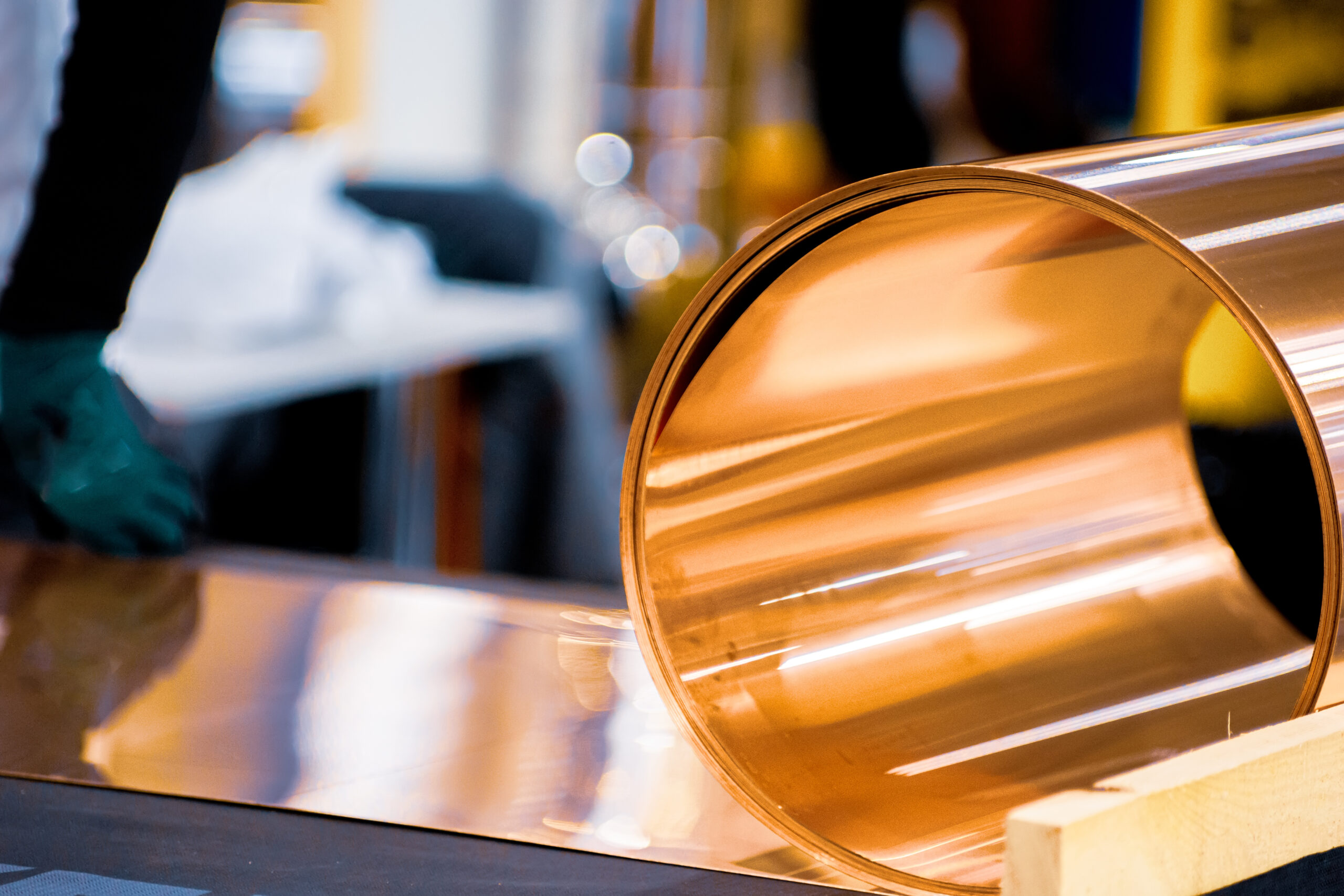 A section of sheet metal is pulled through a roll forming machine on a factory floor