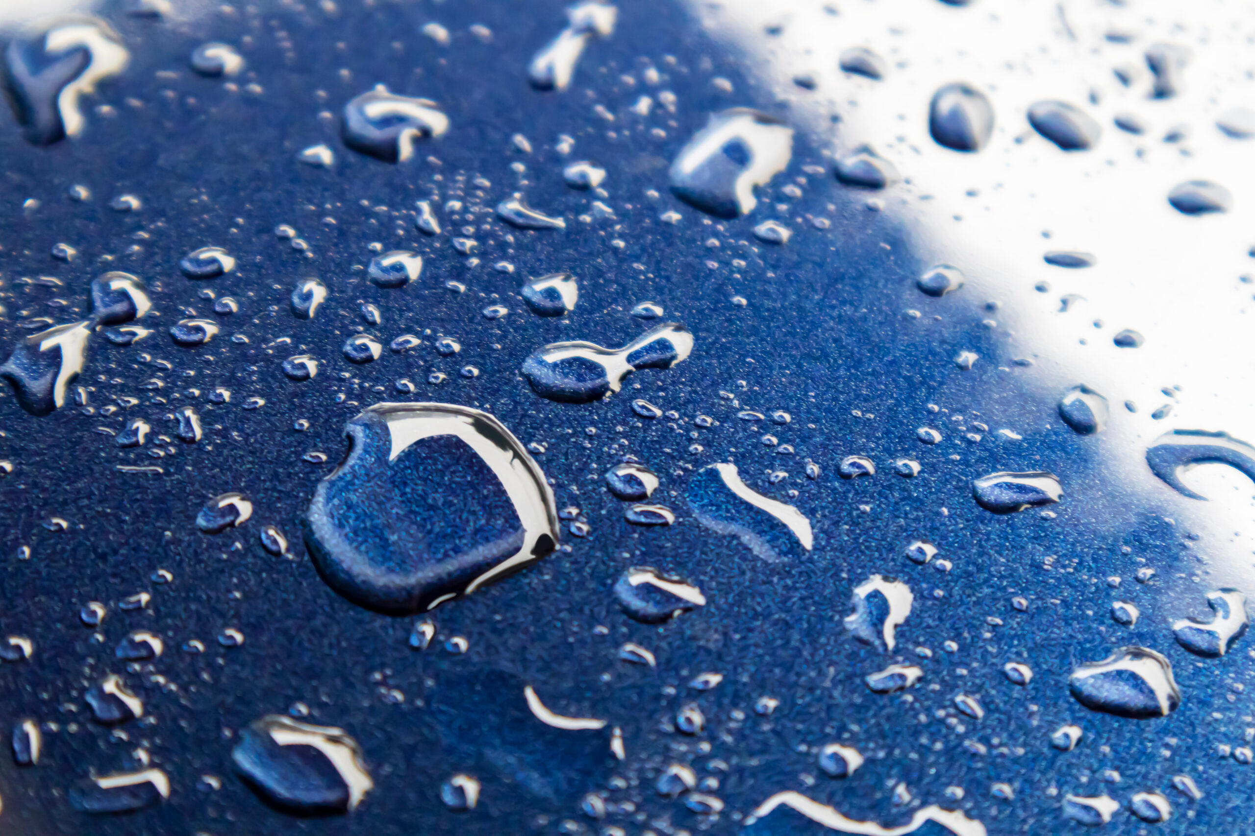 Water drops on blue powder coated surface, focus view.