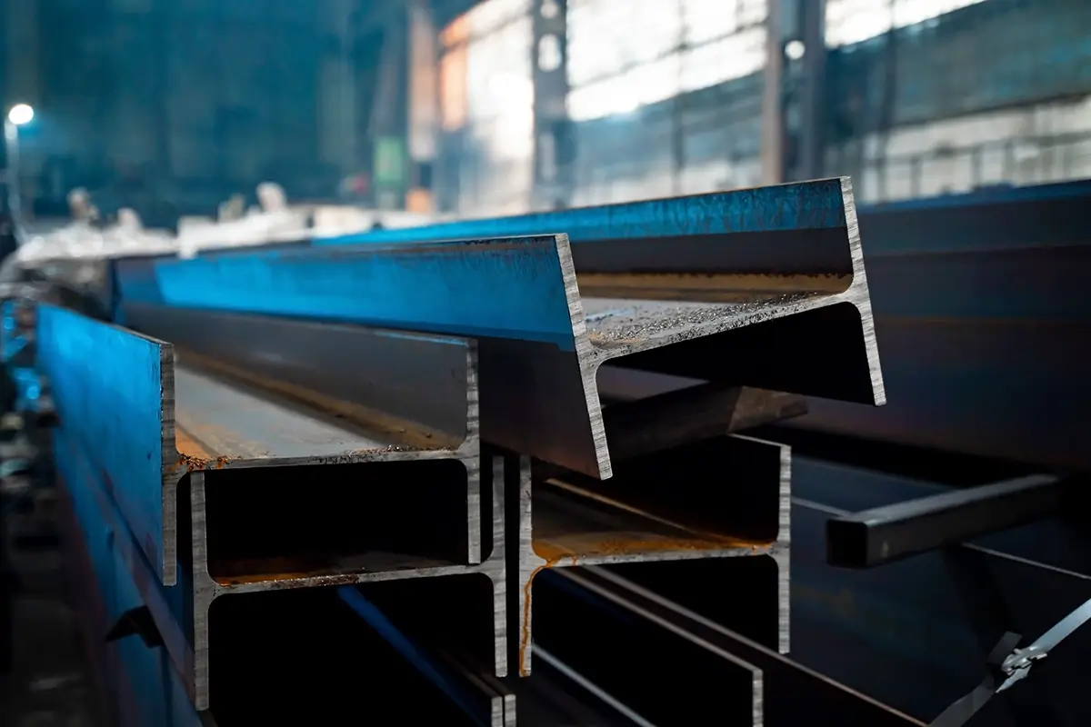 A section of sheet metal is pulled through a roll forming machine on a factory floor